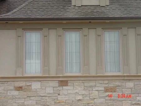Pale stone masonry beneath windows in an Indiana Rubble Custom Blend reference