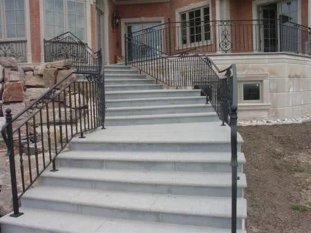 Granite entrance staircase with rounded step edges and adjacent stonework
