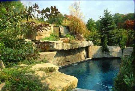 Large natural stone slabs and planting around a garden pond