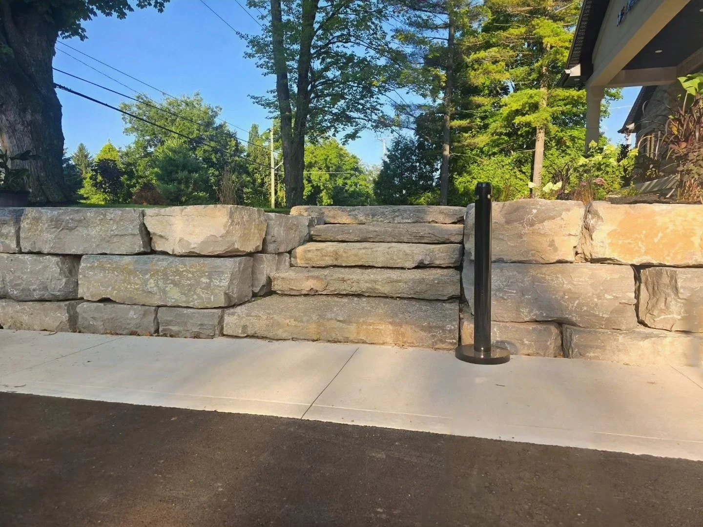 Natural armour stone retaining wall around a landscaped outdoor space