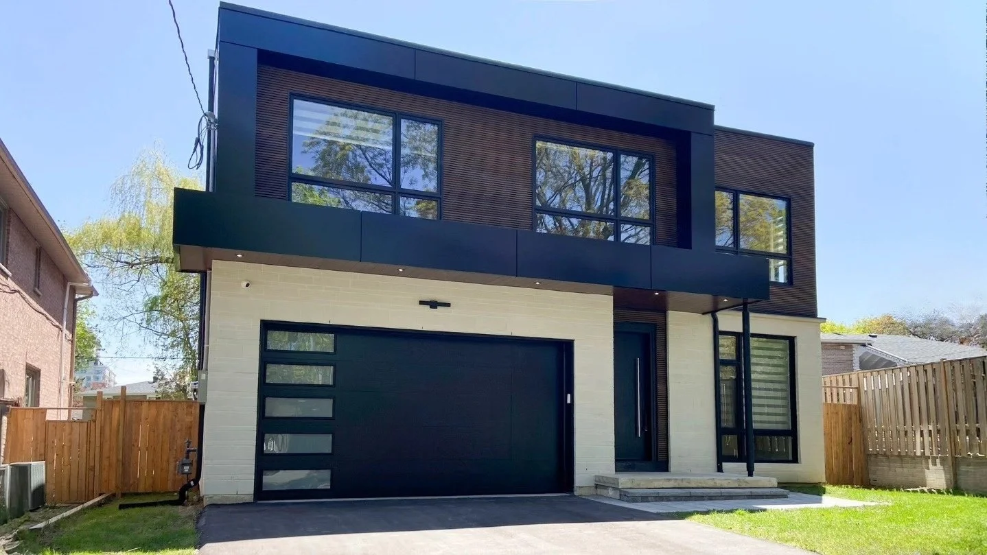 Contemporary stone-clad house with a dark framed upper storey and large windows