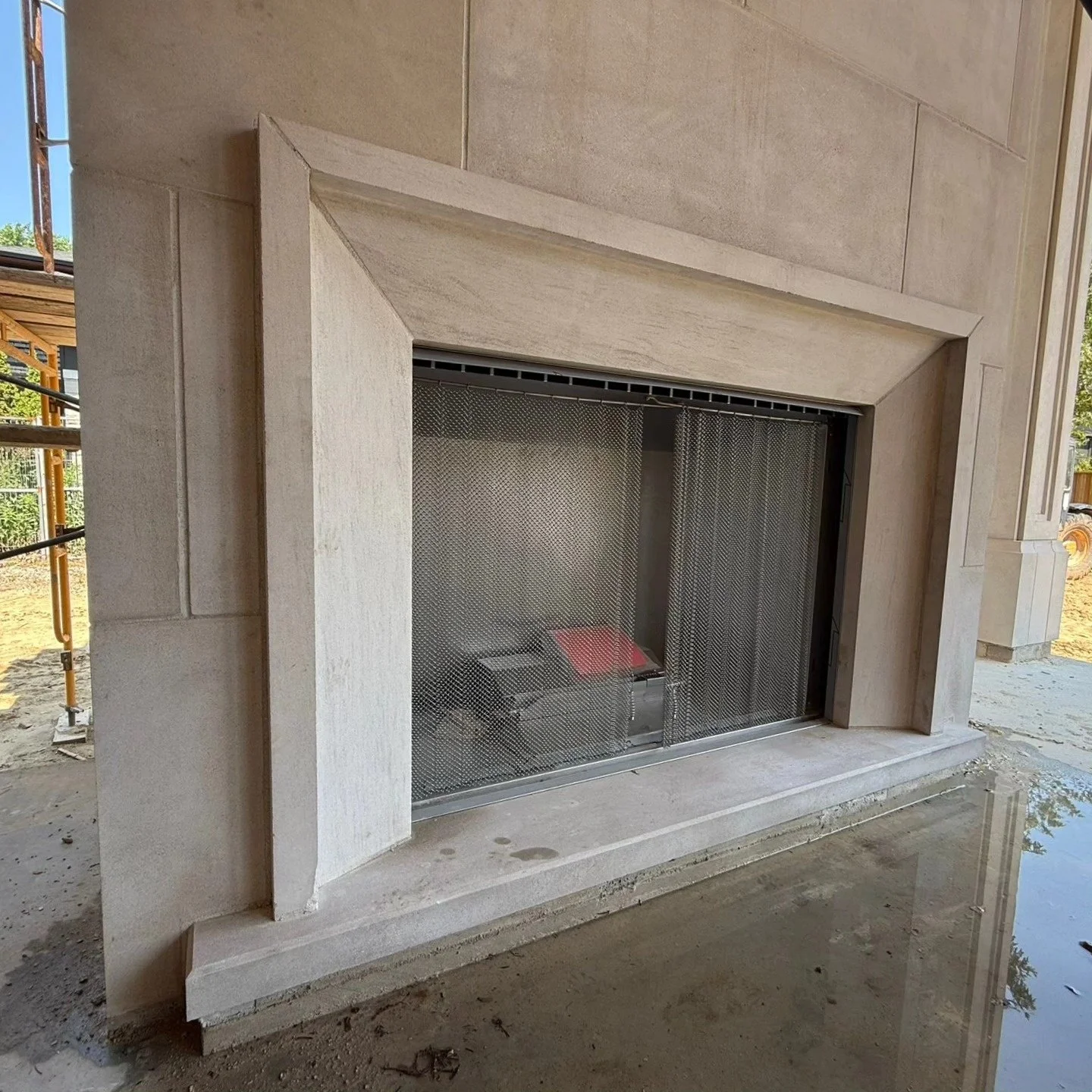 Custom pale limestone fireplace surround in a sheltered outdoor living area