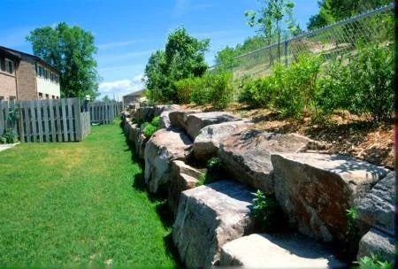 Muskoka Peach granite retaining wall alongside a planted garden