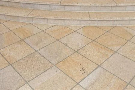 Buff granite paving laid diagonally beside curved entrance steps